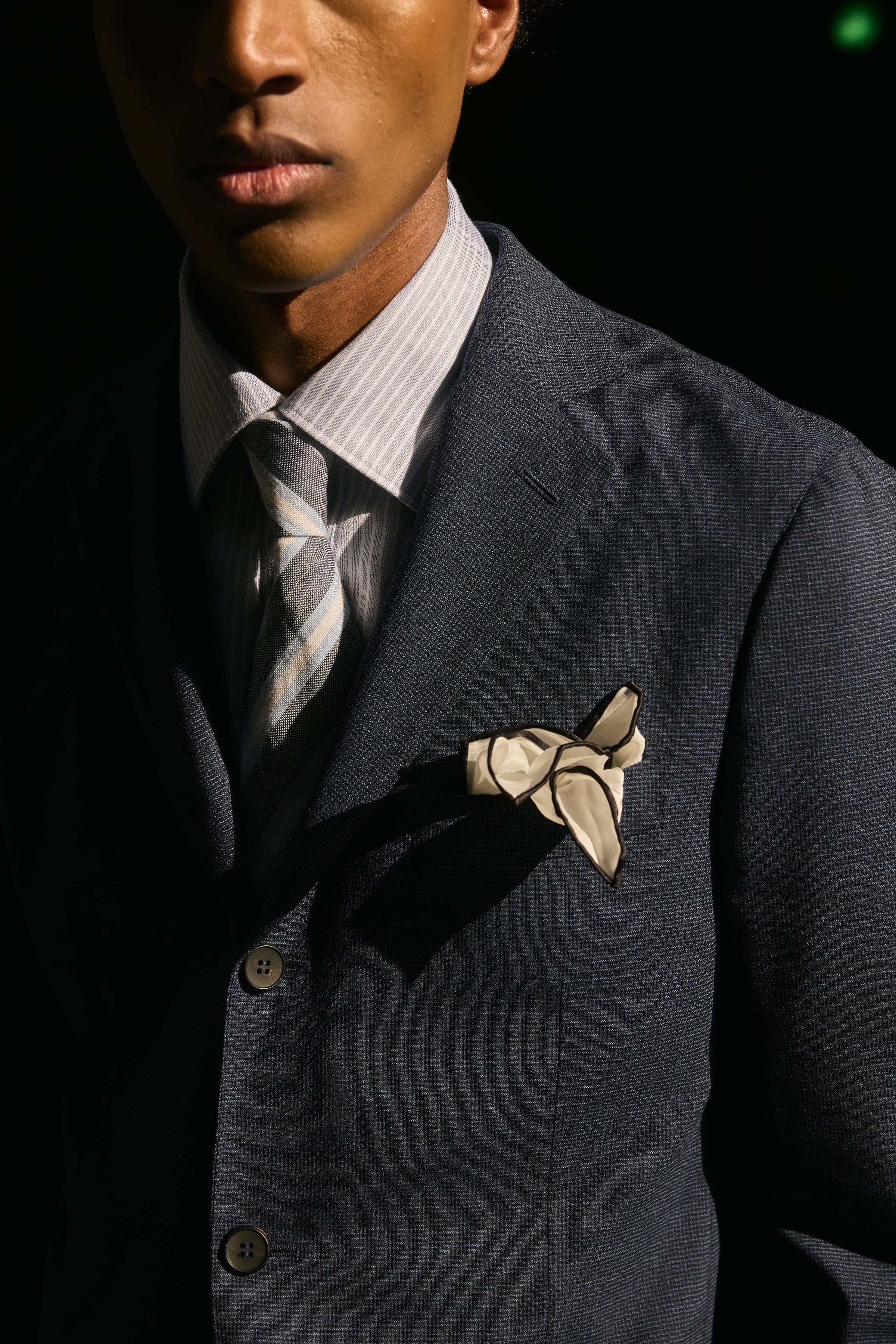 The front of a double breasted evening jacket with a silk pocket square